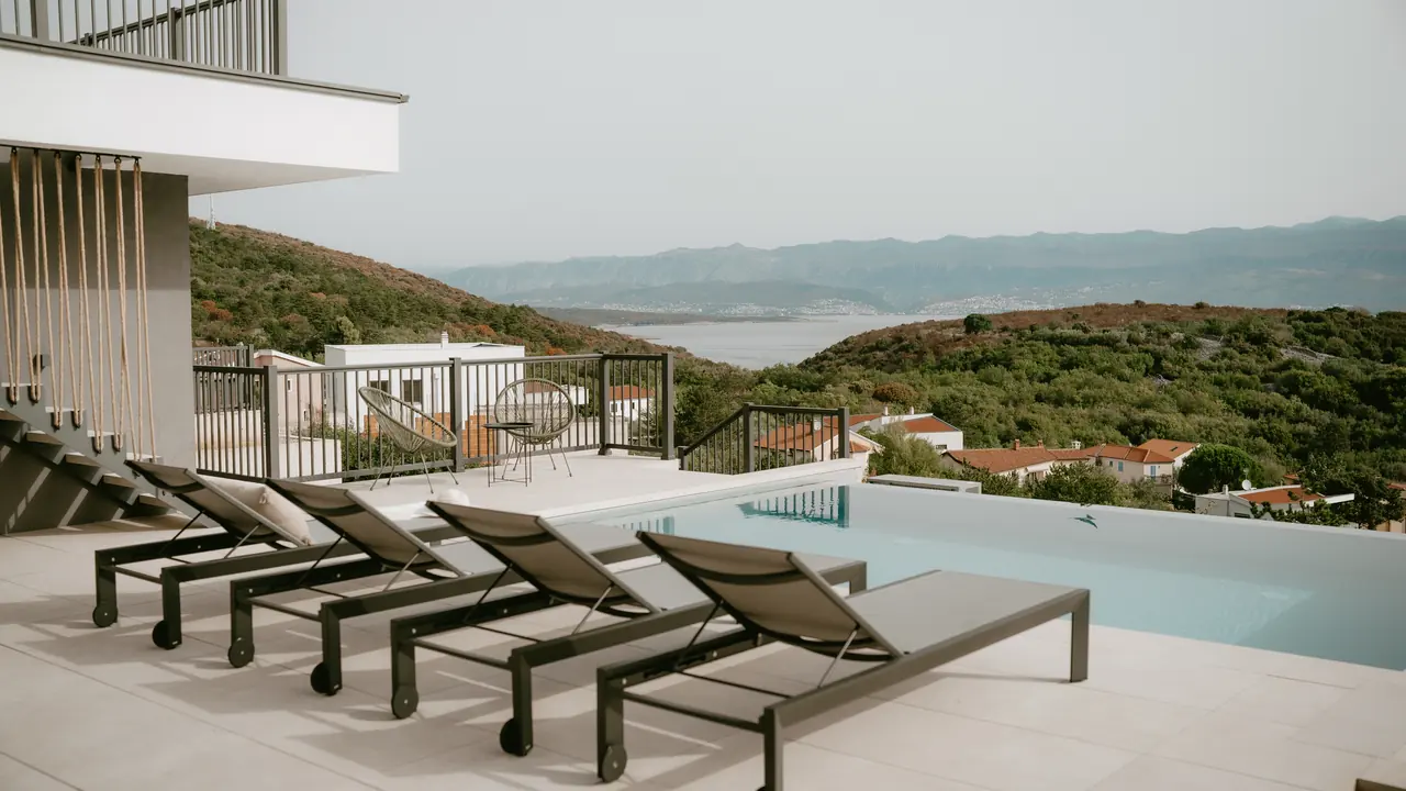 Heated infinity pool with sun loungers